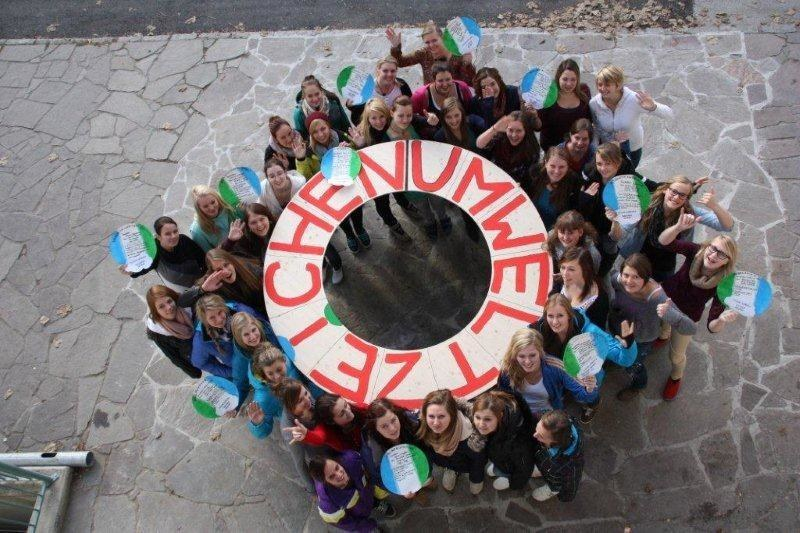 Schüler:innen halten ein Banner mit "Umweltzeichen" hoch