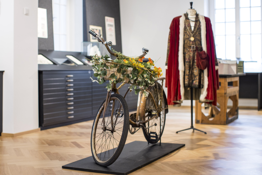 Ausstellungsraum im Festspielarchiv. Im Bild ein Fahrrad der Jedermann Aufführung von 2013 sowie das Jedermann Kostüm von 1947
