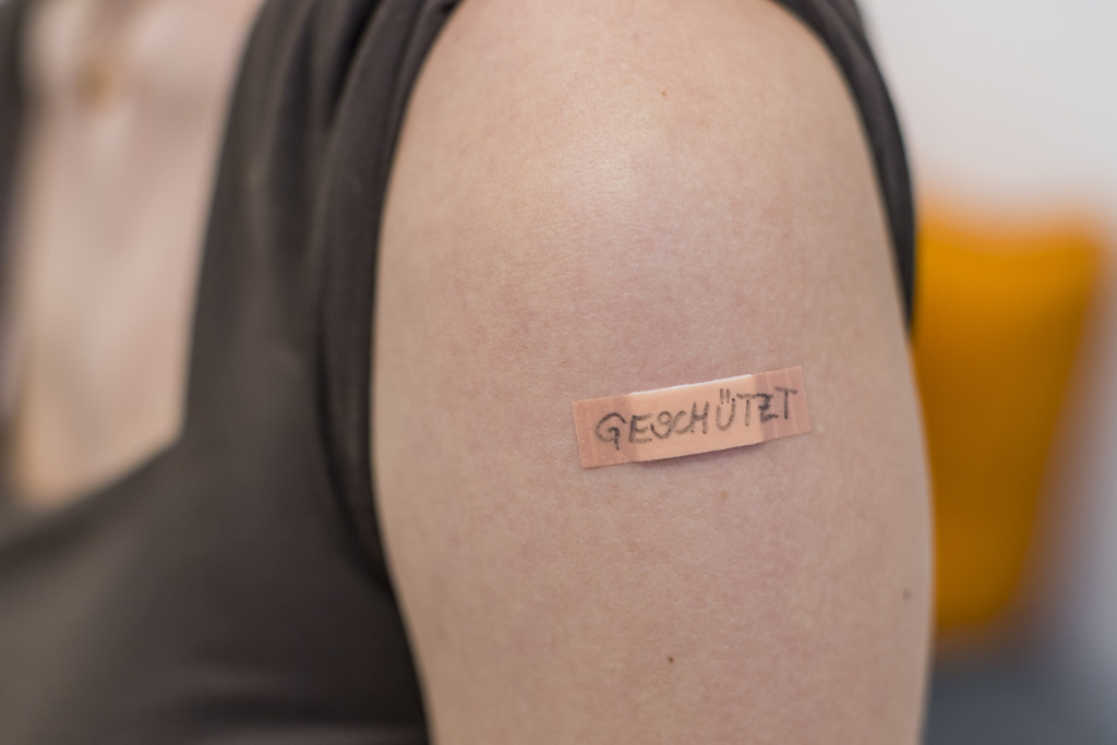 Oberarm mit Pflaster nach der Impfung