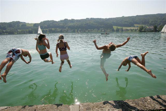 Kinder springen in den See